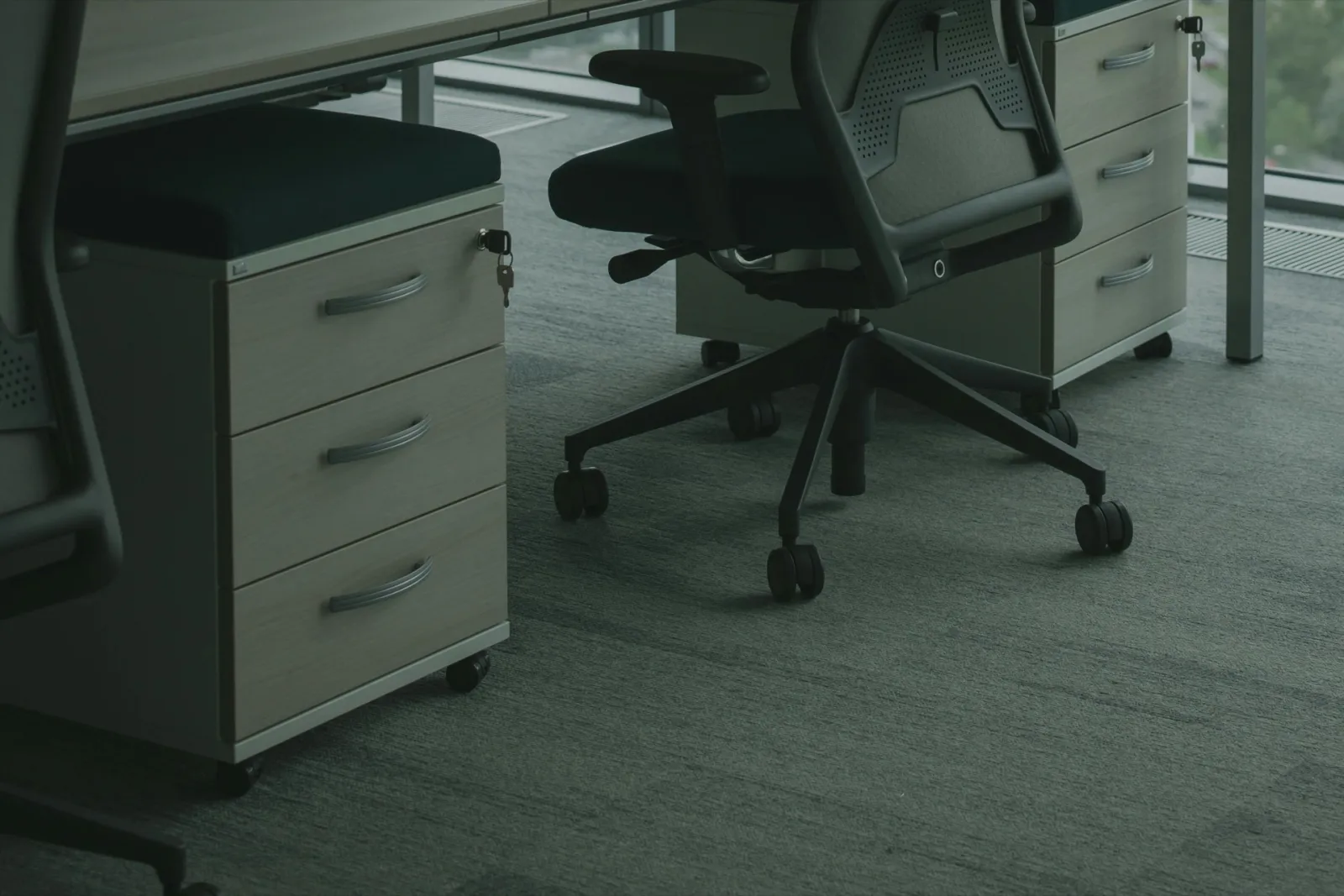 Textile flooring in an office, close-up — carpet under the desk with an office chair.