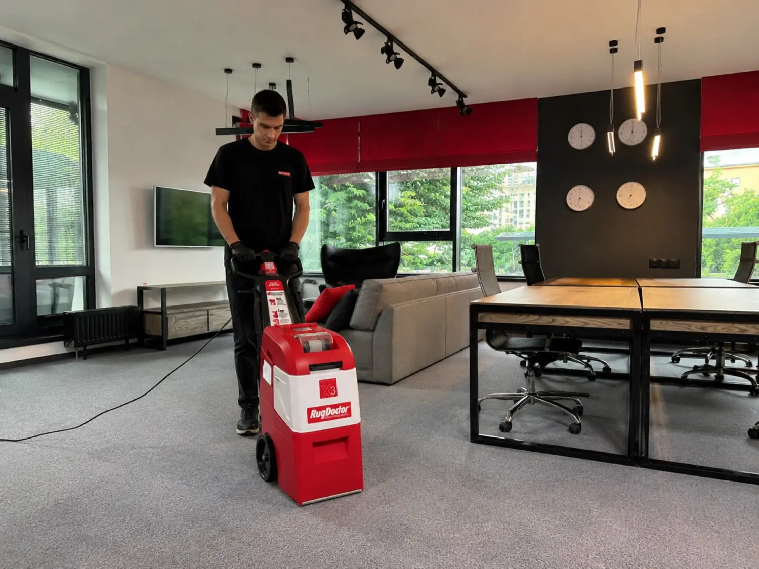 A professional cleaning an office wall-to-wall carpet with a Rug Doctor X3 machine.
